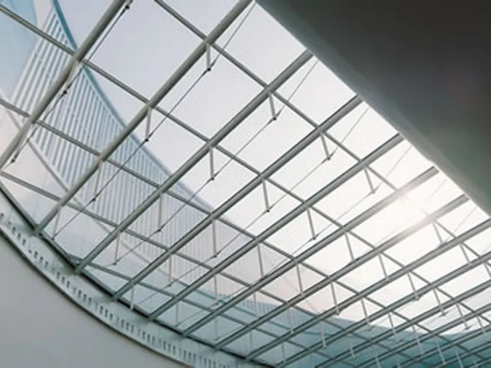 A barrel-vaulted skylight glazed overhead, filmed to cut the heat coming straight down.